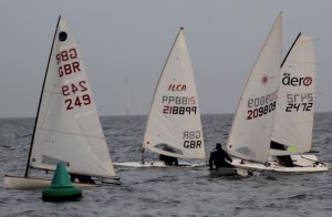 Before the start - Simon Clarke in his Europe, Tim Dye and Ken Potts in Lasers, and Brian Allen in his RS Aero