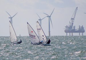 Andy Cornforth, Paul Stanton, and Derroll Pedder against the wind farm backdrop